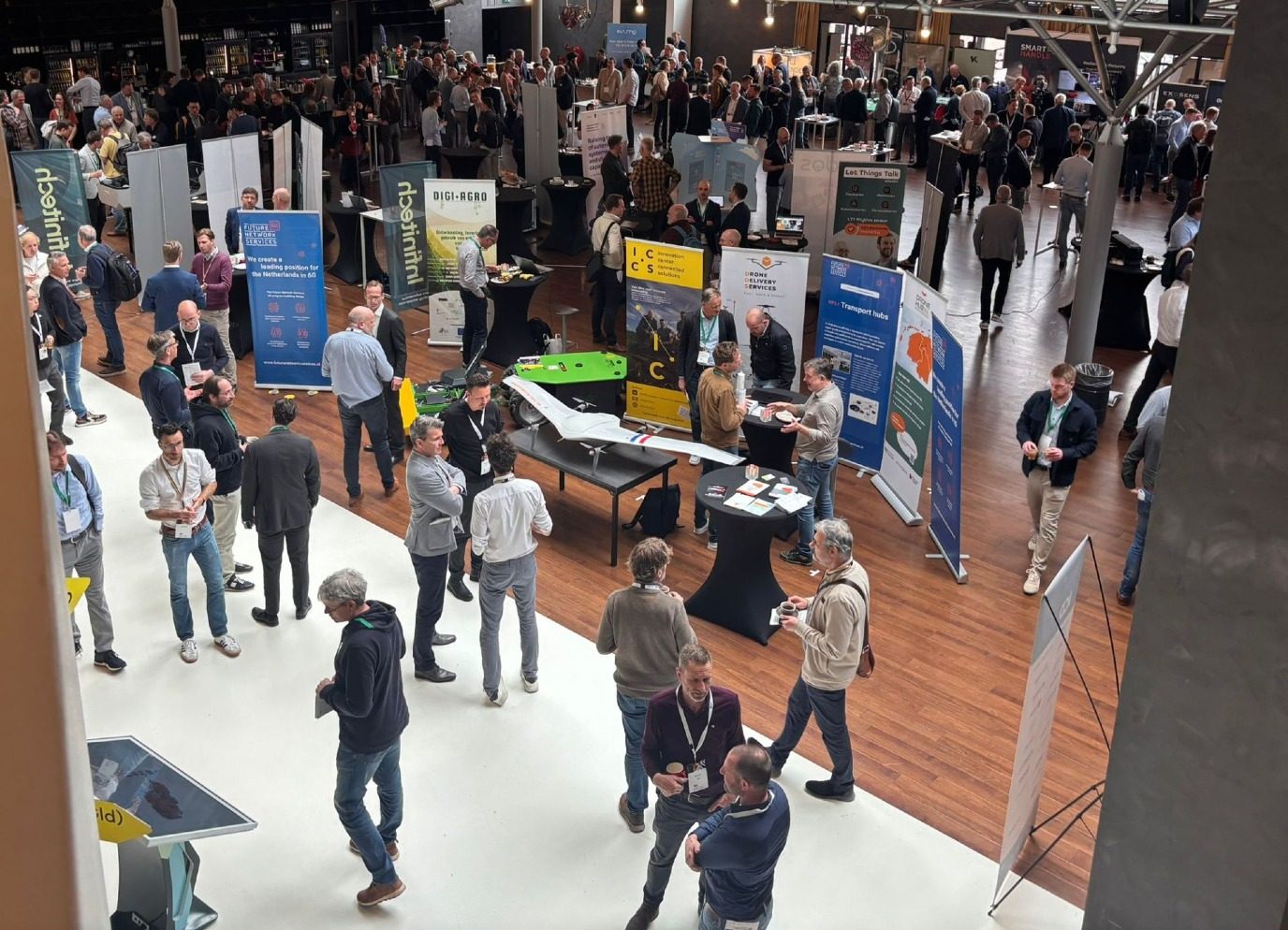 The demonstration floor of the 2026 congress seen from the balcony, with stands and a fixed-wing drone on display