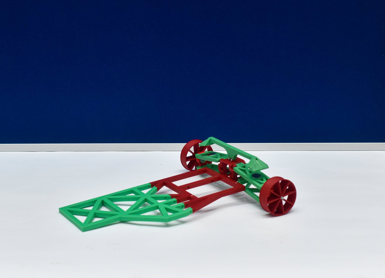 A green and red printed rover chassis built as an open truss, with two red wheels
