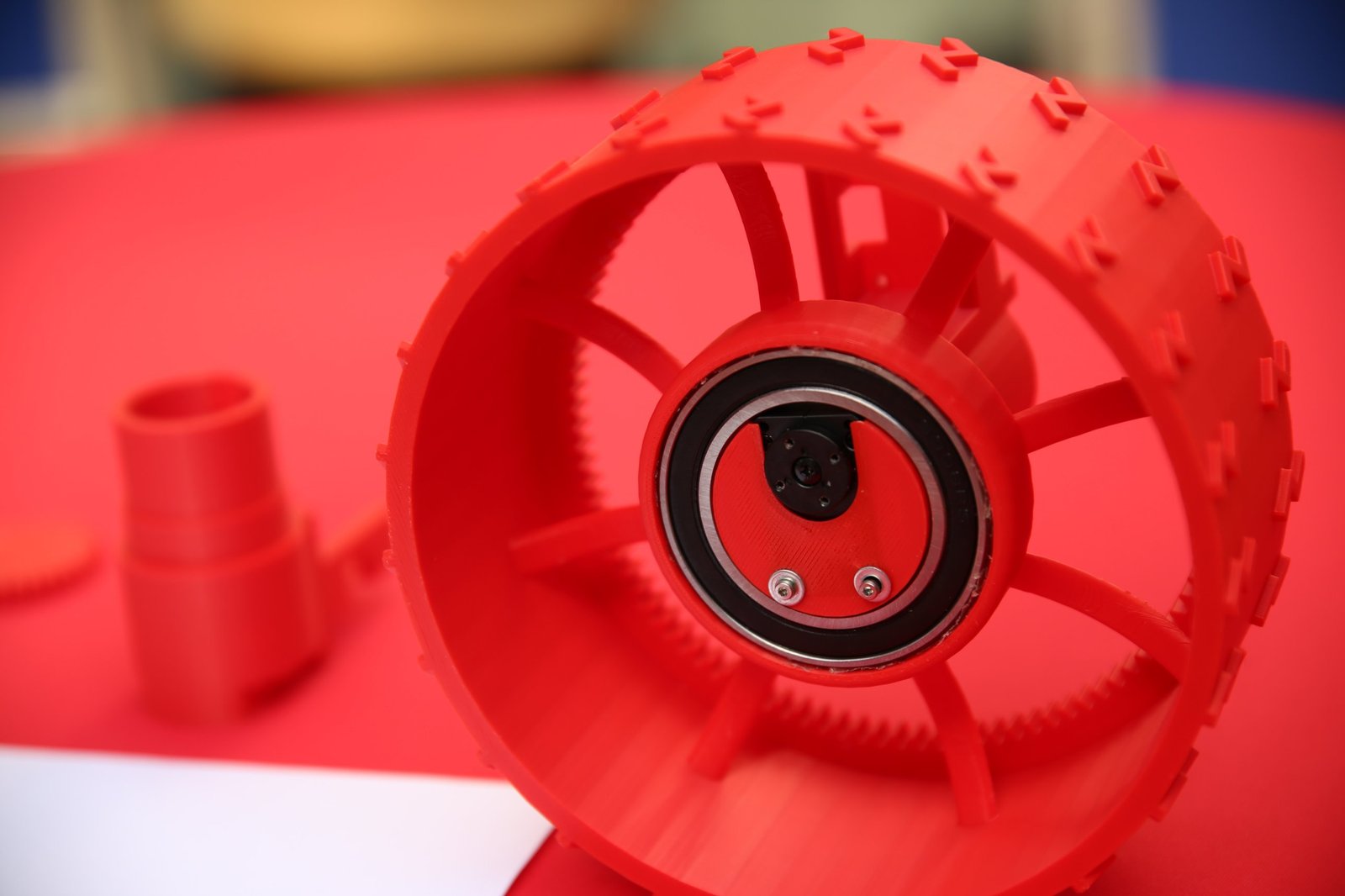 Close-up of a red printed wheel with an internal ring gear and a bearing at its hub